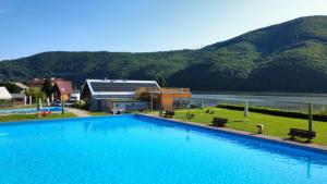 a large swimming pool in front of a mountain at Relaks domki i pokoje nad jeziorem in Międzybrodzie Bialskie