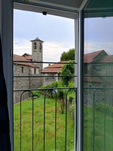 a window with a view of a church at Low-mountain house with terrace and garden, near Lake Maggiore in Maccagno con Pino e Veddasca +31 photos