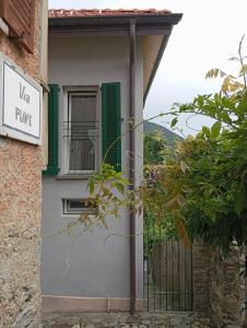 a house with a gate and a sign that reads like pine at Low-mountain house with terrace and garden, near Lake Maggiore in Maccagno con Pino e Veddasca