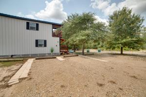 una casa con un cortile di terra accanto a un edificio di Hike and Explore 60-Acre Outdoor Retreat in Tyler! a Tyler