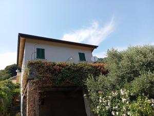 a house with a garage with a building at Low-mountain house with terrace and garden, near Lake Maggiore in Maccagno con Pino e Veddasca