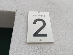 a white sign on a wall with the number two at Low-mountain house with terrace and garden, near Lake Maggiore in Maccagno con Pino e Veddasca