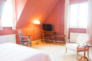 a bedroom with a bed and a table and chairs at Hotel Villa Viktoria Luise in Blankenburg