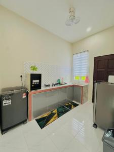 a kitchen with a counter and a refrigerator at Laman Kota Pool Homestay in Kota Sarang Semut