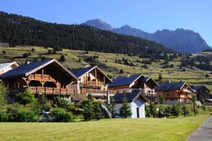 eine Gruppe von Häusern auf einem Hügel mit Bergen im Hintergrund in der Unterkunft Résidence Plein Soleil - Petit duplex 4 pers plein sud sur les hauteurs du village MAE-2803 in Montgenèvre