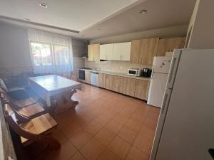 a kitchen with a table and a refrigerator at Pensiunea Melli in Moieciu de Jos