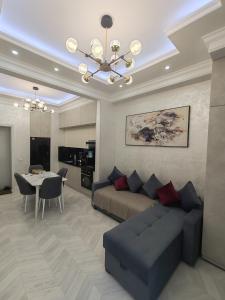 a living room with a couch and a dining room at Tashkent city Gardens E 8-73 in Tashkent