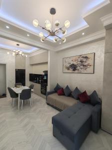 a living room with a couch and a dining room at Tashkent city Gardens E 8-73 in Tashkent