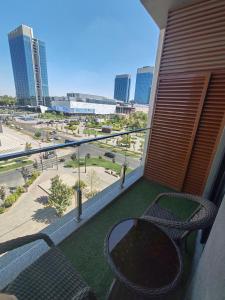 a balcony with a table and chairs and a view of a city at Tashkent city Gardens E 8-73 in Tashkent