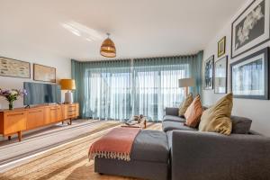 a living room with a couch and a tv at Sunset Townhouse – Pwllheli in Pwllheli
