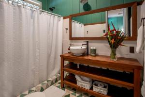 AQUIARES COFFEE FARM CASA HACIENDA LA ESPERANZA في توريالبا: حمام مع ستارة دش بيضاء ومغسلة