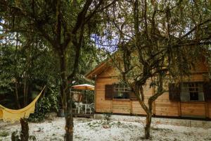 a log cabin with a hammock in front of it at Na Casa da Ilha in Paranaguá