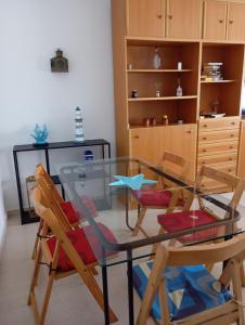 a dining room with a glass table and chairs at Salvora in Bueu +5 photos