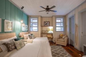 AQUIARES COFFEE FARM CASA HACIENDA LA ESPERANZA في توريالبا: غرفة نوم بها سريرين ومروحة سقف