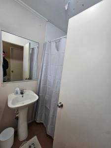 a white bathroom with a sink and a mirror at Departamento diario en Copiapo en quinto piso in Copiapó