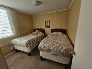 a bedroom with two beds and a teddy bear on the bed at Departamento diario en Copiapo en quinto piso in Copiapó