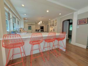 a kitchen with four red bar stools at a counter at Beautiful House in the Woods, Huge Yard, Hot Tub in Great Barrington +50 photos