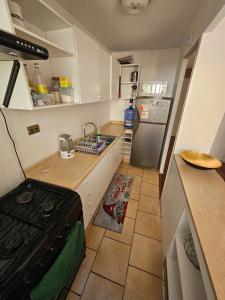 コピアポにあるDepartamento Copayapu 3268の小さなキッチン(コンロ、シンク付) +2枚の写真