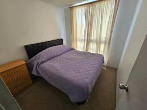 コピアポにあるDepartamento Copayapu 3268のベッドルーム1室(紫色の掛け布団、窓付)