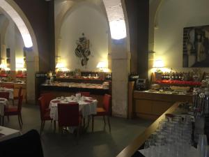 a restaurant with white tables and chairs and a counter at Grande Albergo Alfeo in Syracuse