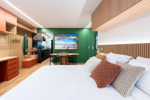 una camera con un letto bianco e una parete verde di Duque 1705 by LikeHome a Porto Alegre Altre 183 foto