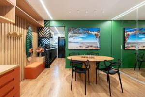 una sala da pranzo con pareti verdi e tavolo e sedie di Duque 1705 by LikeHome a Porto Alegre