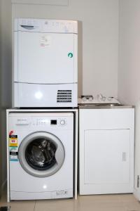 a washing machine and a dryer in a room at Oxleys 404 one bedroom with sea views in Picton