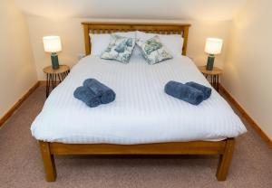 a bedroom with a white bed with two lamps at The Cornerstone in Maghera