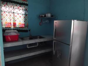 a small kitchen with a sink and a refrigerator at Yvonne's House in Kingston