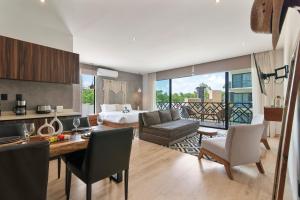 a living room with a bed and a dining room at Unwind | Private Balcony & Rooftop Pools | Casago in Tulum