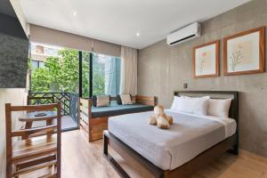 a bedroom with a bed with a teddy bear on it at Unwind | Private Balcony & Rooftop Pools | Casago in Tulum +90 photos
