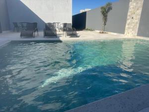 a pool of water with chairs and a table at FLATs UTOPIA in Capitólio