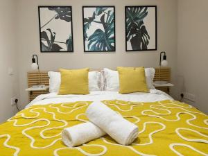 a bedroom with a large bed with a yellow and white blanket at Central Bury Apartment with Private Entrance in Bury Saint Edmunds