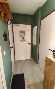 a room with green walls and a white door at Le Cocon Pyrénéen - Ski aux pieds & Parking Privé in Les Angles