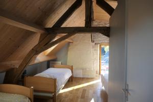 a attic bedroom with two beds and a window at la roche coeur in Vouvray
