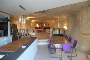 a kitchen and dining room with a table and purple chairs at la roche coeur in Vouvray