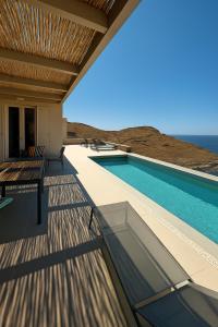 a house with a swimming pool on a deck at Kythnos Sunset View Villa in Flampouria