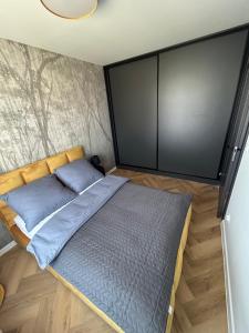 a bed in a room with a wall at Apartament Grafitowy in Nysa