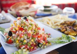 a plate of salad with corn salsa and other foods at Sahara horizon Camp in Merzouga