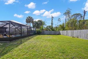 a large yard with a fence and a house at Mermaid Landing - St Joe Beach by Coastline Vacation Rentals in Saint Joe Beach