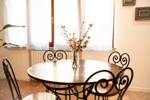 a dining room table with chairs and a vase with flowers at All'ombra del Duomo in Ascoli Piceno