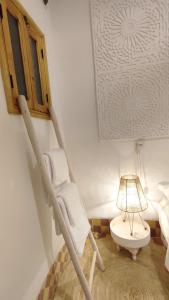 Maison en exclusivité 2 chambre Place Jemma El Fna في مراكش: غرفة بها كرسي هزاز ومصباح