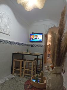 Maison en exclusivité 2 chambre Place Jemma El Fna في مراكش: غرفة معيشة مع طاولة وتلفزيون