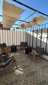 Maison en exclusivité 2 chambre Place Jemma El Fna في مراكش: غرفة بها كراسي ومظلات على السطح