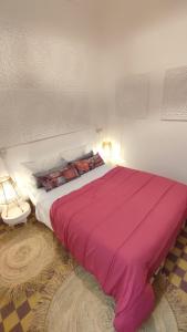 Maison en exclusivité 2 chambre Place Jemma El Fna في مراكش: سرير وردي كبير في غرفة النوم مع مصباحين +16 صورة