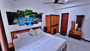 a bedroom with a white bed and a television at A-ONE Residency in Colombo +18 photos