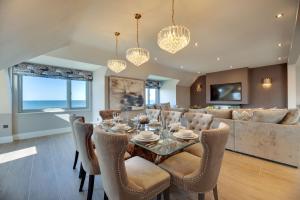 una sala da pranzo con tavolo, sedie e divano di Coot's Nest Seahouses a Seahouses