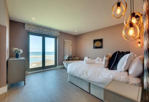 una camera da letto con un letto grande con vista sull'oceano di Coot's Nest Seahouses a Seahouses
