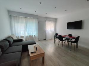 ein Wohnzimmer mit Sofa und Tisch in der Unterkunft Benicarló Vacation Apartment in Benicarló