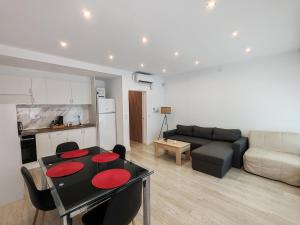 ein Wohnzimmer mit einem schwarzen Tisch und einem Sofa in der Unterkunft Benicarló Vacation Apartment in Benicarló